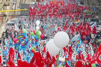 Bandiere e palloncini con i colori dei sindacati durante una sfilata di protesta.