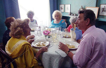 Una familia seduta a pranzo a ferragosto. Immagine d'archivio.