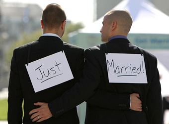 Coppia gay fotografata di spalle con la scritta "Just married"