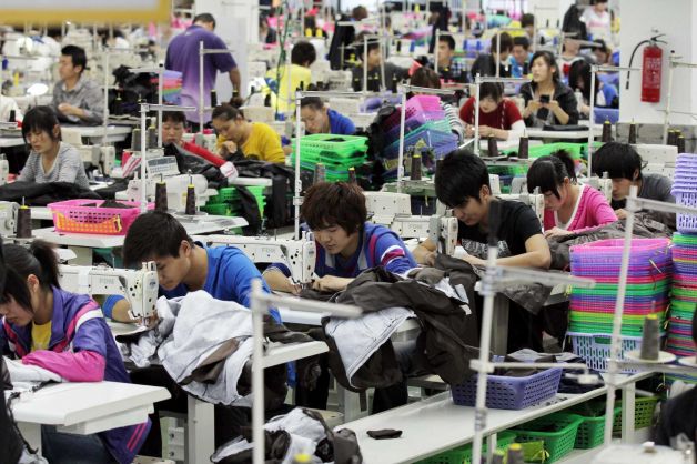 Operai lavorano in un laboratorio tessile cinese.