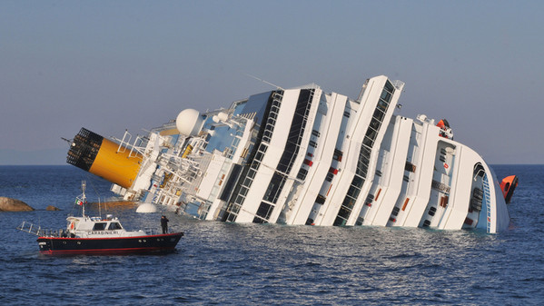 Costa Concordia inclinato sulla fiancata affondata, sulla costa dell'Isola del Giglio.