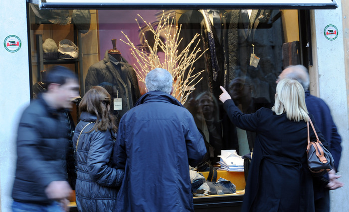 Persone davanti a un negozio di abbigliamento, in una via del centro di Roma.