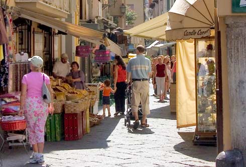 Turisti camminando tra le bancarelle di un mercatino. Confcommercio
