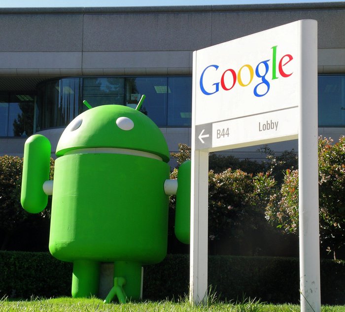 Un robot gigante verde simbolo di Android a lato di un cartellone con la scritta Google.