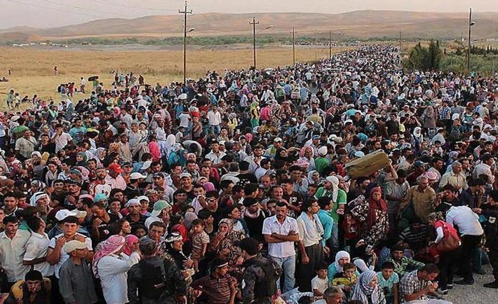 Migranti assiepati in un campo profughi.