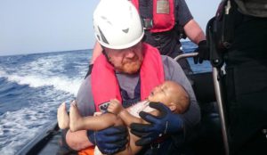 In this Friday, May 27, 2016 photo, a Sea-Watch humanitarian organization crew member holds a drowned migrant baby, during a rescue operation off the coasts of Libya. Survivor accounts have pushed to more than 700 the number of migrants feared dead in Mediterranean Sea shipwrecks over three days in the past week, even as rescue ships saved thousands of others in daring operations. (Christian Büttner/EIKON NORD GMBH GERMANY via AP)