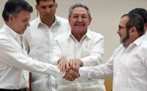 TOPSHOTS Colombian President Juan Manuel Santos (L) and the head of the FARC guerrilla Timoleon Jimenez, aka Timochenko (R), shake hands as Cuban President Raul Castro (C) holds their hands during a meeting in Havana on September 23, 2015.  AFP PHOTO / Luis Acosta