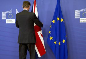 A member of protocol adjusts the British flag prior to a meeting of British Prime Minister David Cameron and European Commission President Jean-Claude Juncker at EU headquarters in Brussels on Friday, Jan. 29, 2016. (ANSA/AP Photo/Virginia Mayo)