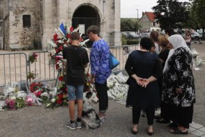 Residents pay tribute at a makeshift memorial in front of the Saint Etienne church where Priest Jacques Hamel was killed on 26 July in a hostage taking in Saint-Etienne-du-Rouvray, Normandy, France, Thursday, July 28, 2016. The second man who attacked a Normandy church during a morning Mass this week, slitting the throat of the elderly priest, is a 19-year-old Frenchman from eastern France, the prosecutor's office said Thursday. (ANSA/AP Photo/Francois Mori)