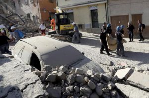 A body is carried away as a car is covered in rubble after an earthquake, in Amatrice, central Italy, Wednesday, Aug. 24, 2016. (ANSA/AP Photo/Alessandra Tarantino) 