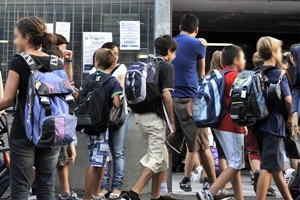 Studenti all'entrata della scuola con lo zainetto in spalla.