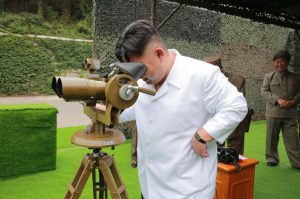 This undated photo distributed on Tuesday, Sept. 6, 2016, by the North Korean government shows North Korean leader Kim Jong Un looking though binoculars at the site of a ballistic missile launching at an undisclosed location in North Korea.  (Korean Central News Agency/Korea News Service via AP) 
