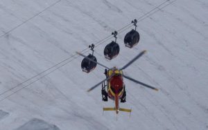 An EC-135 helicopter operated by the French Societe' Civile hovers, Friday, Sept. 9, 2016, near three cars of the Panoramic Mont Blanc cable car that stalled around 4 p.m. (1400 GMT) on Thursday, after its cables reportedly tangled.  (ANSA/AP Photo/Luca Bruno) 
