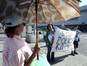 Polly Usher is provided with the latest police killing story as protestors holds a  sign that reads 'Stop Police Killings' during a demonstration in Los Angeles, California, USA, 07 July 2016. EPA/MIKE NELSON