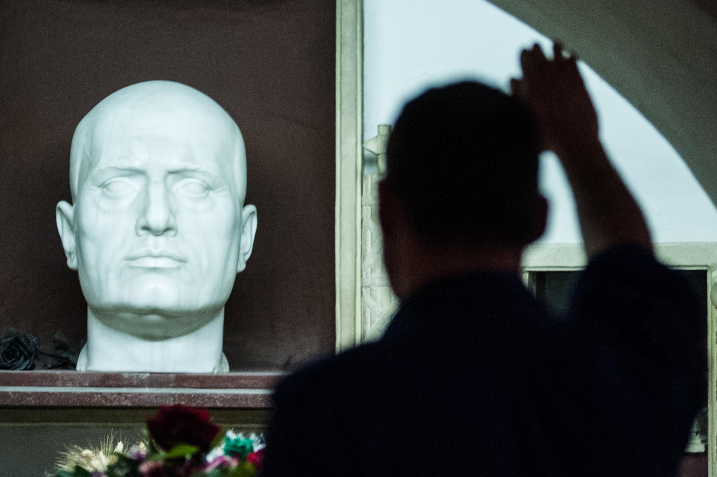 Saluto fascista al busto di Benito Mussolini.