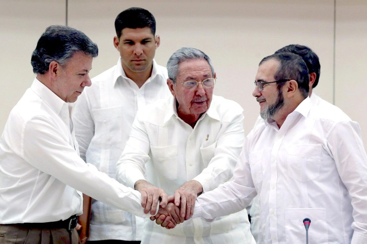 Il presidente cubano Raul Castro stringe le mani del presidente colombiano Juan Manuel Santos e il leader delle FARC Rodrigo Londono 'Timochenko' Echeverri, tutti in camicia bianca, a conclusione della trattativa di pace. Archivio