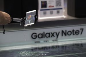 FILE - In this Thursday, Sept. 1, 2016 file photo, a man holds a Samsung's latest Galaxy Note 7 smartphone after dipping it in water to test its waterproofing features at a roadshow booth outside a shopping mall in Beijing. (ANSA/AP Photo/Andy Wong, File) 