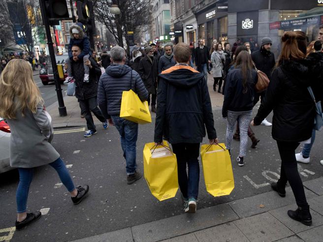 Persone camminano per strada con le borse degli acquisti.