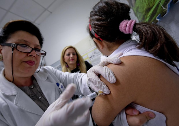 Dottoressa vaccinando una ragazza. Vaccini