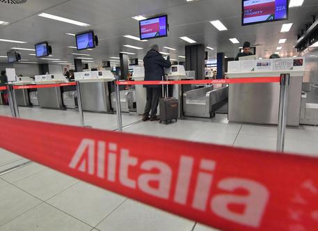 Un passeggero in attesa a uno dei check in Alitalia dell'aeroporto di Linate.