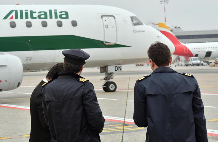 Un equipaggio di Alitalia si avvia verso l'aereo.
