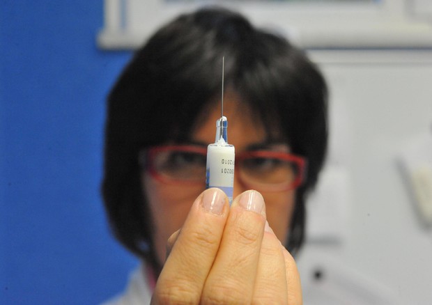 Una dottoressa con una siringa in mano controlla il livello del vaccino