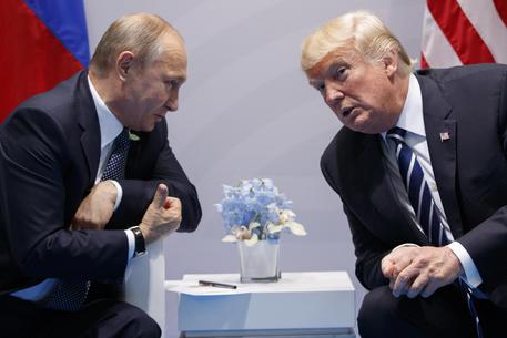 Trump e Putin si stringono la mano.