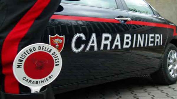 Fiancata di un'auto pattuglia dei Carabinierie e la paletta rossa infilata nel gambale