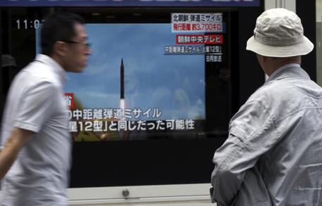 Corea del Nord, delle persone guardano lo schermo della tv il lancio di un missile. Hanoi