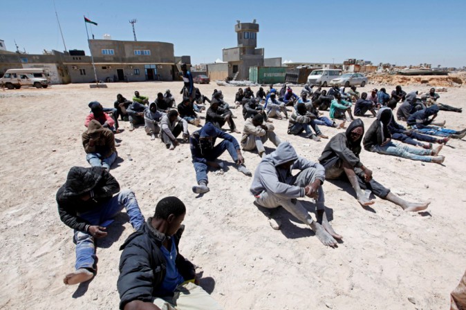 Migranti sulla spiaggia in attesa di imbarcare.
