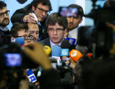 Carlos Puigdemont circondato dai giornalisti dà dichiarazioni.