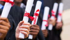 Mani di studenti universitari con il diploma di laurea. Istat