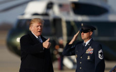 Donald Trump imbarcandosi sull'Air Force One, un ufficiale saluta militarmente.