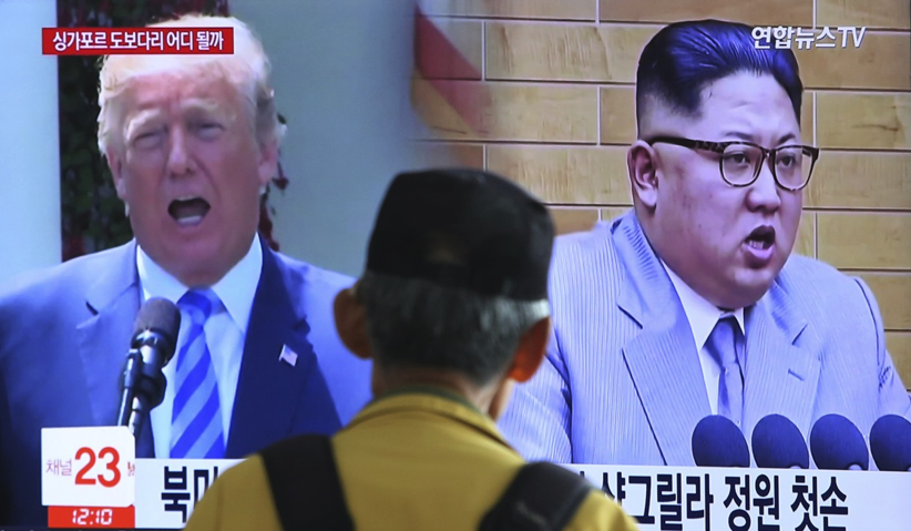 Un uomo di spalle mentre guarda uno schermo gigante della tv che trasmette la notizia della rottura tra Trump e Kim. Summit