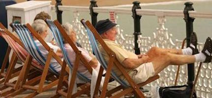 Anziani seduti sulle sedie a sdraio al sole