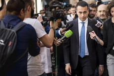 Il leader del M5s Luigi Di Maio esce dal ristorante per recarsi ai gruppi parlamentari, circondato da giornalisti e microfoni tesi