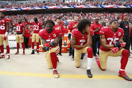San Francisco 49ers back-up quarterback Colin Kaepernick in ginocchio durante l'inno nazionale. per protestare contro il razzismo verso gli afroamericani.