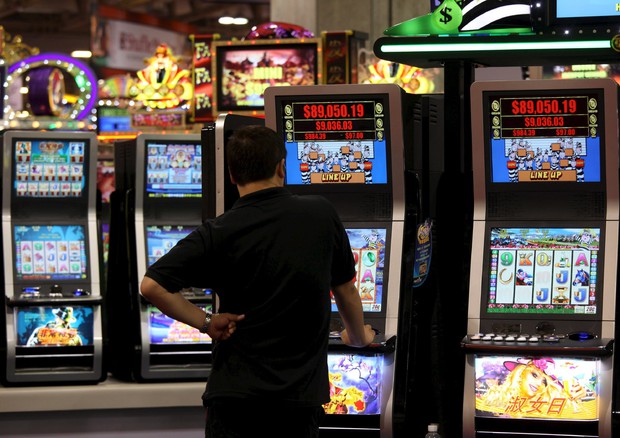 Una persona in piedi di fronte a slot machine
