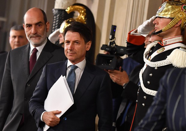 Giuseppe Conte, dopo la consulta con il presidente Mattarella. A lato un corazziere lo saluta militarmente prima del discorso di accettazione con riserva.