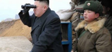 Kim Jong-un osserva con un cannocchiale l'orizzonte, al suo lato un soldato coreano.