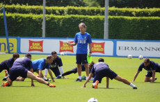 Roberto Mancini al centro dirige l'allenamento degli azzurri, intorno a lui facendo esercizi a terra.