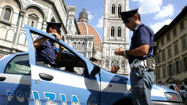 Pattuglia di poliziotti in macchina, posto di blocco su una piazza di Firenze. Reati