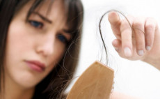 Una mujer con el cabello que le queda en el cepillo