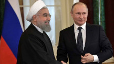 Hassan Rohani e Vladimir Putin si stringono la mano.