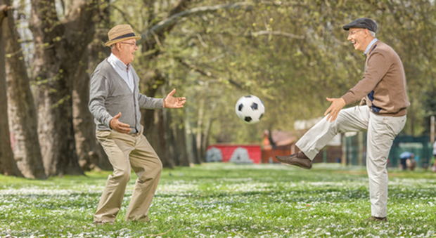 Due centenari palleggiando un pallone da calcio
