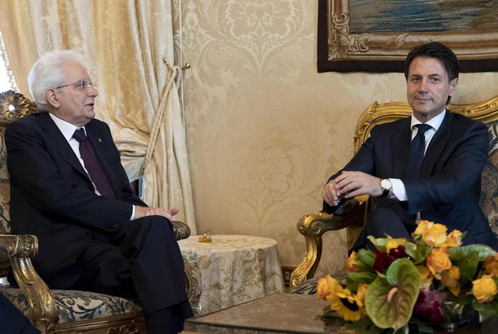 Il presidente della Repubblica Sergio Mattarella e il premier incaricato Giuseppe Conte seduti sui divani sorridono ai fotografi.