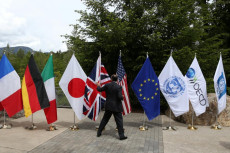 Un funzionario controlla le bandiere dei paesi partecipanti al G7 in Canada.