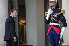 Emmanuel Macron entra al Palazzo dell'Eliseo, salutato dalla guardia presidenziale.