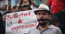 Un giornalista con la bocca chiusa e un giornale con la scritta in rosso "Libertad de expresión"