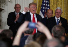 Il presidente americano Donald Trump circondato da un gruppo di suoi sostenitori.